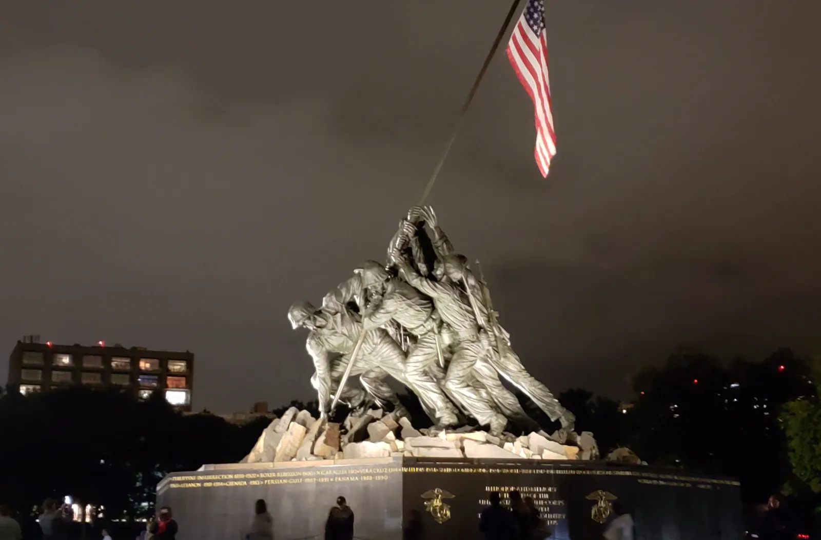 The U.S. Marine Corps War Memorial and flag against a dark sky